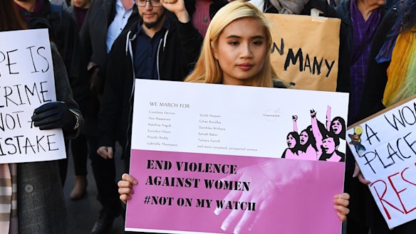 Protesters hold placards as they march through Melbourne to protest violence against women in June.