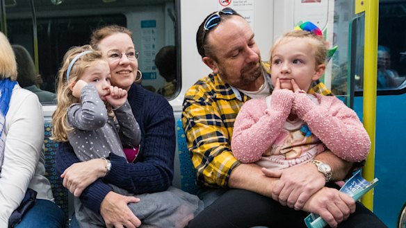 Tony Williams and wife Jacqui on board a metro train on Sunday with their daughters, Annika, left and Liesl.