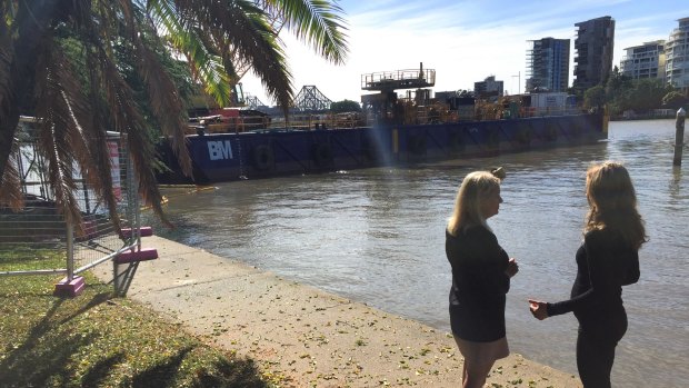 Deputy mayor Krista Adams and Bicycle Queensland chief executive Anne Savage at the City Botanic Gardens inspect the barge being used for the riverwalk construction.