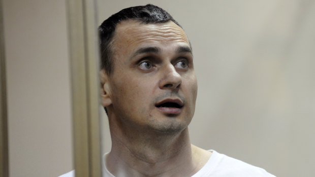 Oleg Sentsov stands behind bars as his verdict is read at a court in Rostov-on-Don, Russia, in 2015.