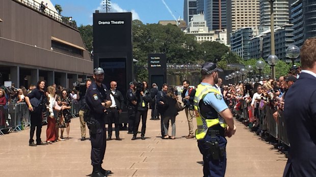 Crowds and security waiting for Harry and Meghan to appear.