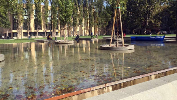 A reflection pool among Parma buildings proves a refreshing place for a picnic.