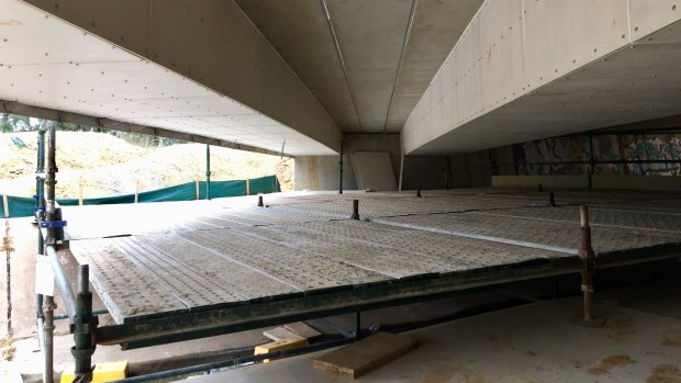 Scaffolding installed under a bridge on Flemington Road, where two sets of cable trunking – enclosures used to protect electrical cables – have been installed.
