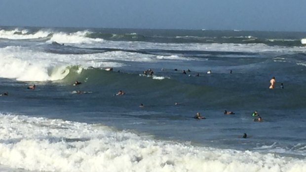 Swimmers and surfers in the ocean off Moffat Beach on the Sunshine Coast on Sunday.
