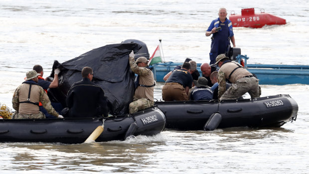 Rescuers in inflatable boats transport what appear to be bodies of victims near the Margaret Bridge where a sightseeing boat capsized in the Danube river in Budapest, Hungary.