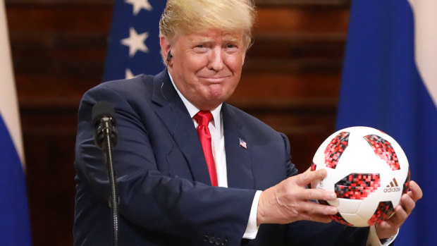 Donald Trump accepts a soccer ball from Vladimir Putin.