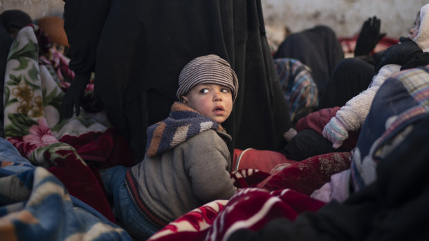 Women and children sit in the back of a truck as they wait to be screened by US-backed Syrian Democratic Forces  after being evacuated out of the last territory held by Islamic State militants last month.