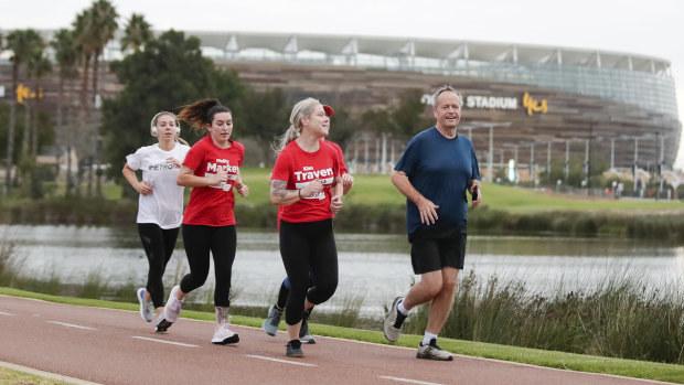 Opposition Leader Bill Shorten runs past the Optus Stadium during an early morning run along the Swan River in Perth.