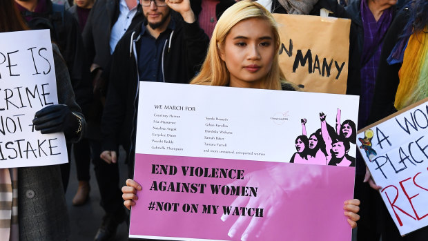 Protesters hold placards as they march through Melbourne to protest violence against women in June.