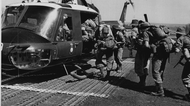 "Infantrymen of The First Battalion, Royal Australian Regiment, loaded down with full kits and carrying rifles, crowd into an Iroquois helicopter bound for the front-line area of the recent Skyhigh Two exercise. "