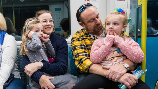 Tony Williams and wife Jacqui on board a metro train on Sunday with their daughters, Annika, left and Liesl.