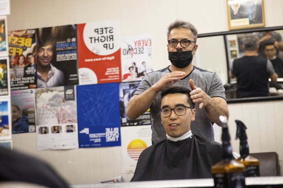 Yarraville Barber Henry Minassian cuts Tim Su’s hair on Friday.

Photograph by Paul Jeffers
The Age NEWS
22 Oct 2021