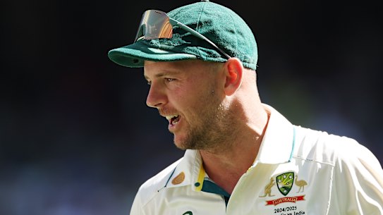 Josh Hazlewood looks on. 
