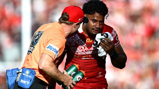 Eli Katoa is helped from the field after a head knock while playing for Tonga.