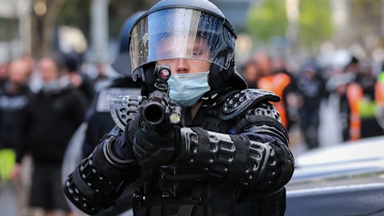 A member of the Critical Incident Response Team is seen with a non-lethal capsicum canister firearm during a protest at the CFMEU headquarters on Monday.