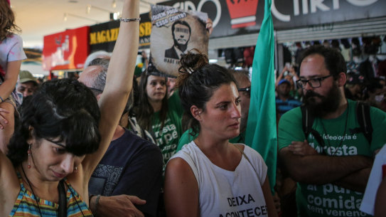 Demonstrators hold signs while gathering during an Amazon in the Streets protest in Brazil. 