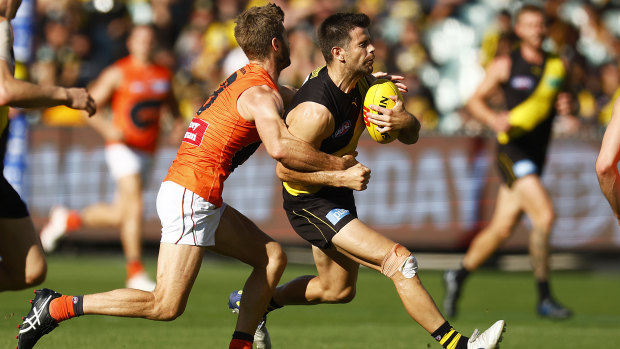 Former Richmond skipper Trent Cotchin looks to burst clear of a tackle from Callan Ward.