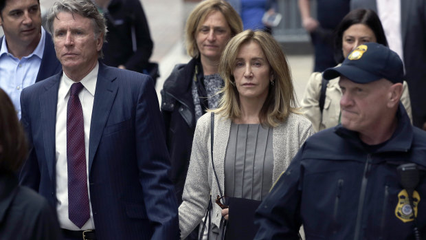 Felicity Huffman, centre, departs federal court with her brother Moore Huffman Jr.