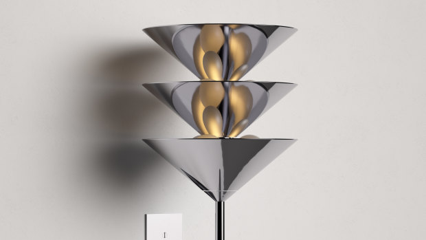 This wall light features a trio of cones nesting in a vertical stack supported by a metal framework. 