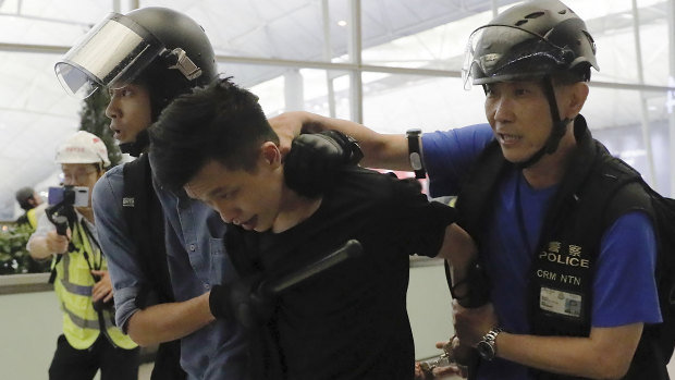 Policemen arrest a protester during Tuesday's violence at Hong Kong airport.