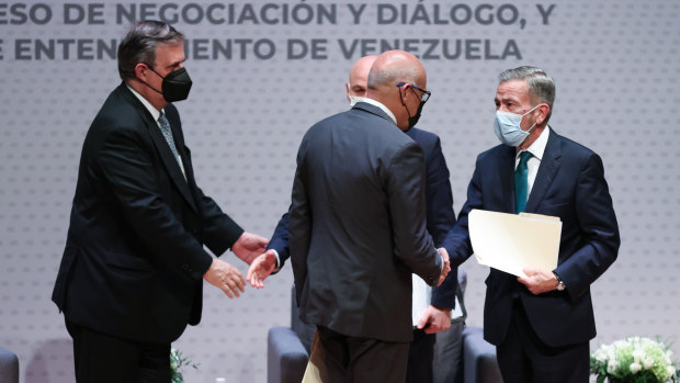 Jorge Rodriguez, president of the National Assembly of Venezuela and Gerardo Blyde Perez, head of the opposition delegation of Venezuela shake hands, right, at the start of talks in Mexico City.