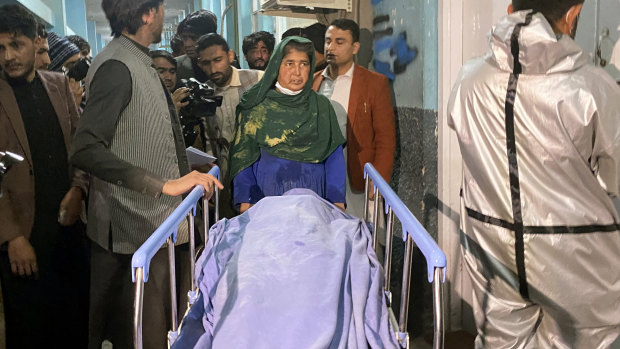 Afghans carry the body of a woman, one of three media workers killed by gunmen in Jalalabad, east of Kabul, Afghanistan.