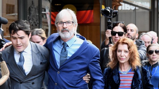 Actor John Jarratt (centre), wife Rosa Miano (right) and his lawyer Bryan Wrench (left) leave the Downing Centre Court on Friday.