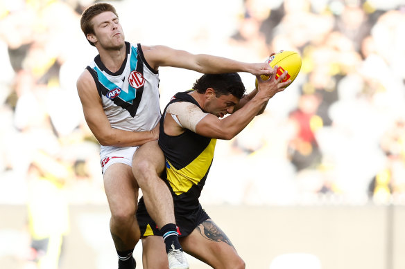 Tim Taranto of the Tigers and Dylan Williams of the Power collide at the MCG on Sunday.