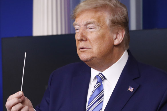 Testing times: US President Donald Trump holds a swab that could be used in a coronavirus test.