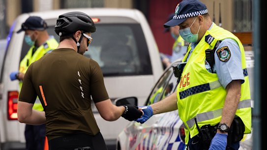 Police check the details of a cyclist at a road block in August 2021.