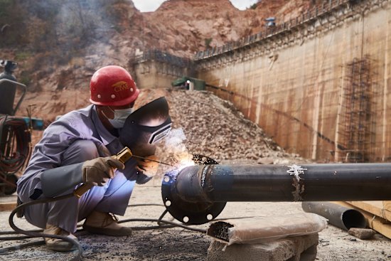 An employee of China Water & Electric Corp welds pipework at the construction site of the Gwayi-Shangani dam, 245km north-west of Bulawayo, Zimbabwe, in June.