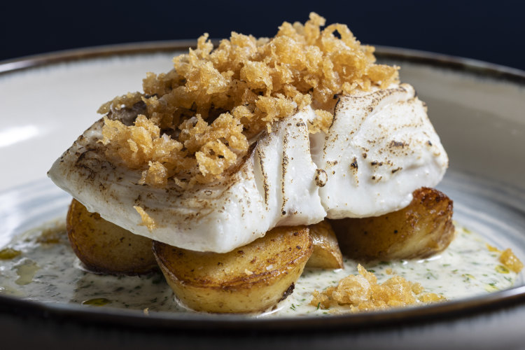 Butter-poached cod fillet topped with beer-batter bits.