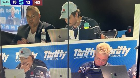 Manly coach Anthony Seibold in the back row of the Waratahs coaches box, with Jason Gilmore (left) and Darren Coleman (right) in the front row.