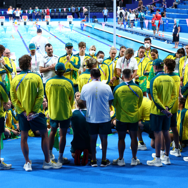 The Australian swim team huddle on pool deck in Paris.