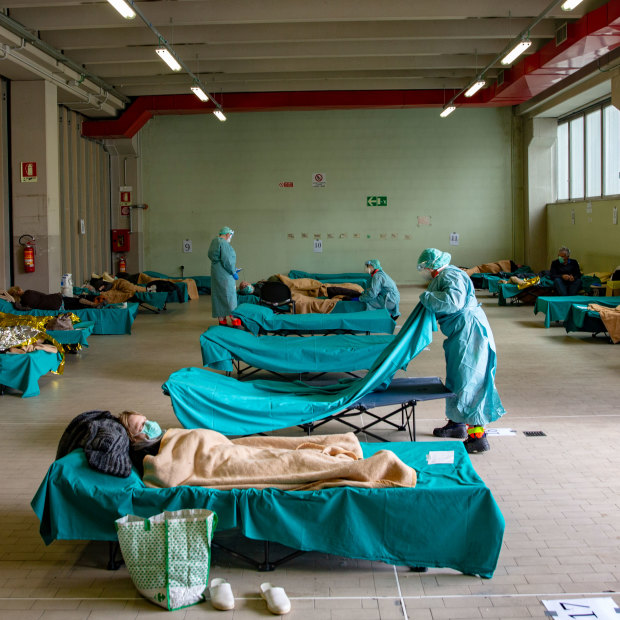Medical personnel in Brescia, northern Italy, care for patients in an emergency temporary room set up to ease pressure on the country's healthcare system.