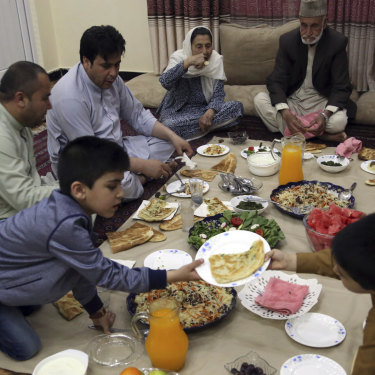 An Afghan family breaks their fast with the Iftar meal at sundown, on the first day of the holy month of Ramadan, in Kabul, Afghanistan.