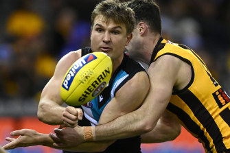 Port Adelaide’s Ollie Wines handballs while being tackled.