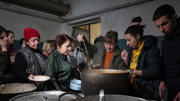 People queue to receive hot food in an improvised bomb shelter in Mariupol, Ukraine on March 7. 
