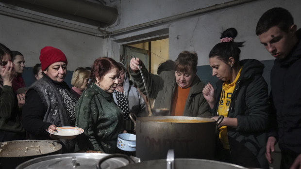 People queue to receive hot food in an improvised bomb shelter in Mariupol, Ukraine on March 7. 