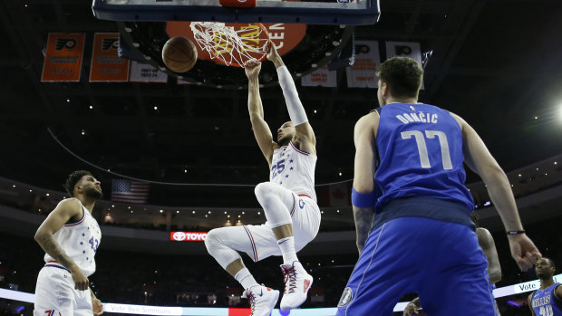 Throwing down: Ben Simmons hangs on the rim after a dunk against the Dallas Mavericks in Philadelphia.