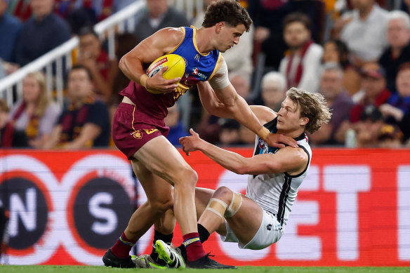 Jarrod Berry of the Lions fends off Xavier Duursma of the Power.