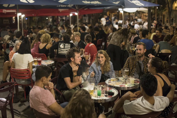 Friends have a drink together at a bar in Marseille, southern France, on Saturday, as new daily cases of COVID-19 passed 10,000 for the first time. 