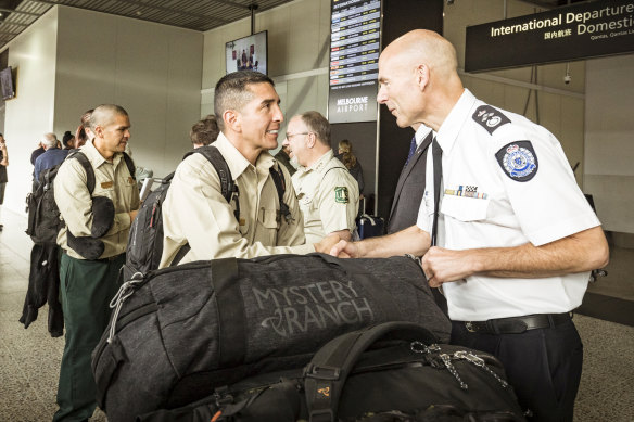 Emergency Management  Commissioner Andrew Crisp greets a firefighter.