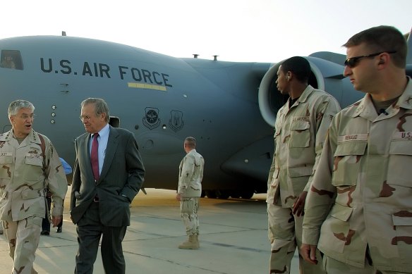Donald Rumsfeld, second from left, arrives at Baghdad International Airport in April 2006.