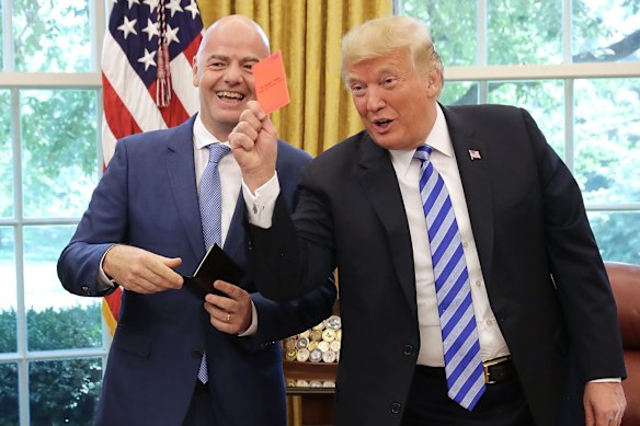 O presidente dos EUA, Donald Trump, finge cartão vermelho aos membros da mídia durante uma reunião com o presidente da FIFA, Gianni Infantino, em agosto de 2018.