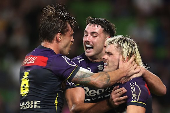 Melbourne Storm’s Cameron Munster, Trent Loiero and Ryan Papenhuyzen celebrate a try.