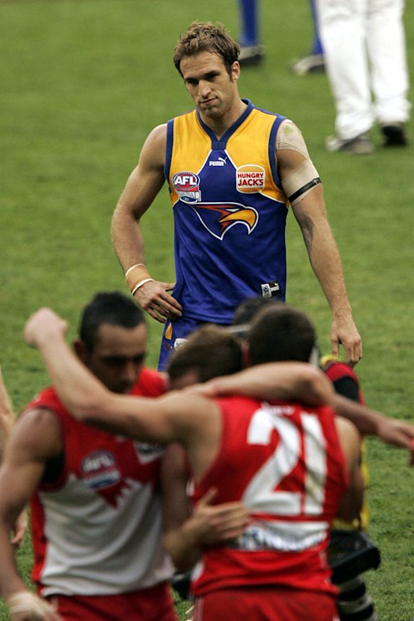 A dejected Chris Judd looks on as Sydney celebrates the 2005 grand final victory over West Coast.
