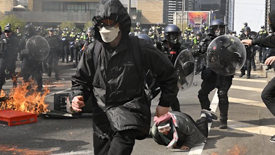 Masked anti-war protesters clash with police during a demonstration against the Land Forces expo in Melbourne in September.