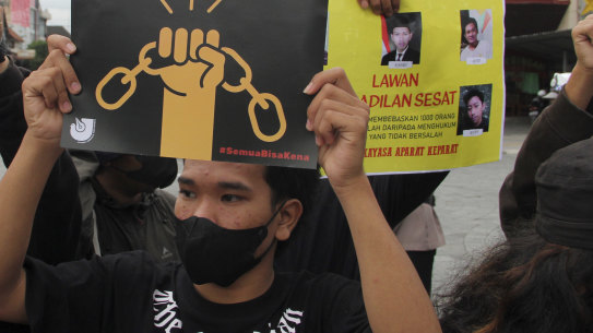 Activists hold up posters during a rally against Indonesia’s new criminal law.