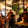 Luis Arana, second from left, and Andrea Tenorio, far right, serving tables while Adobo Tacos is in operation